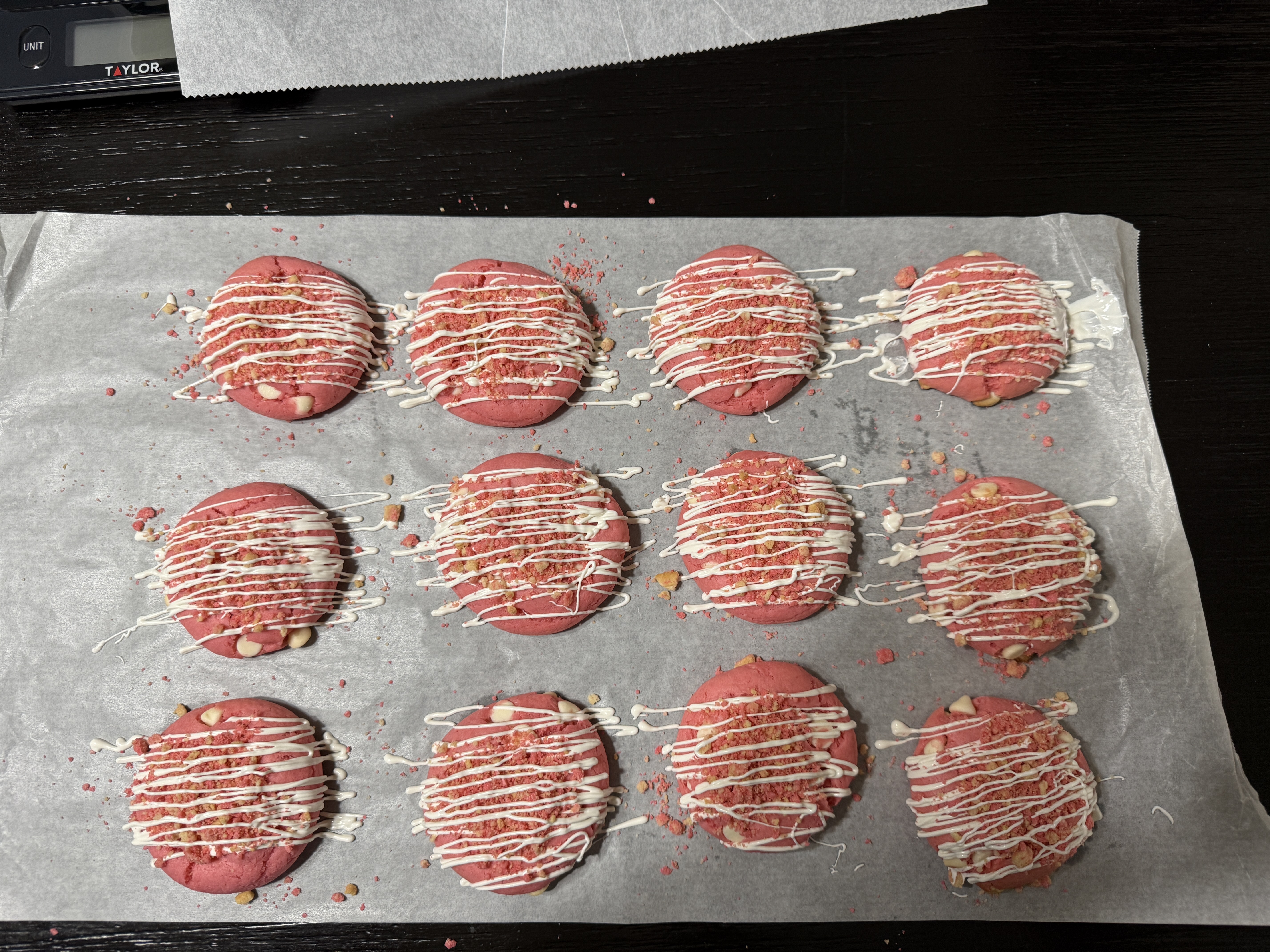 Pink cookies topped with white drizzle and crumbles