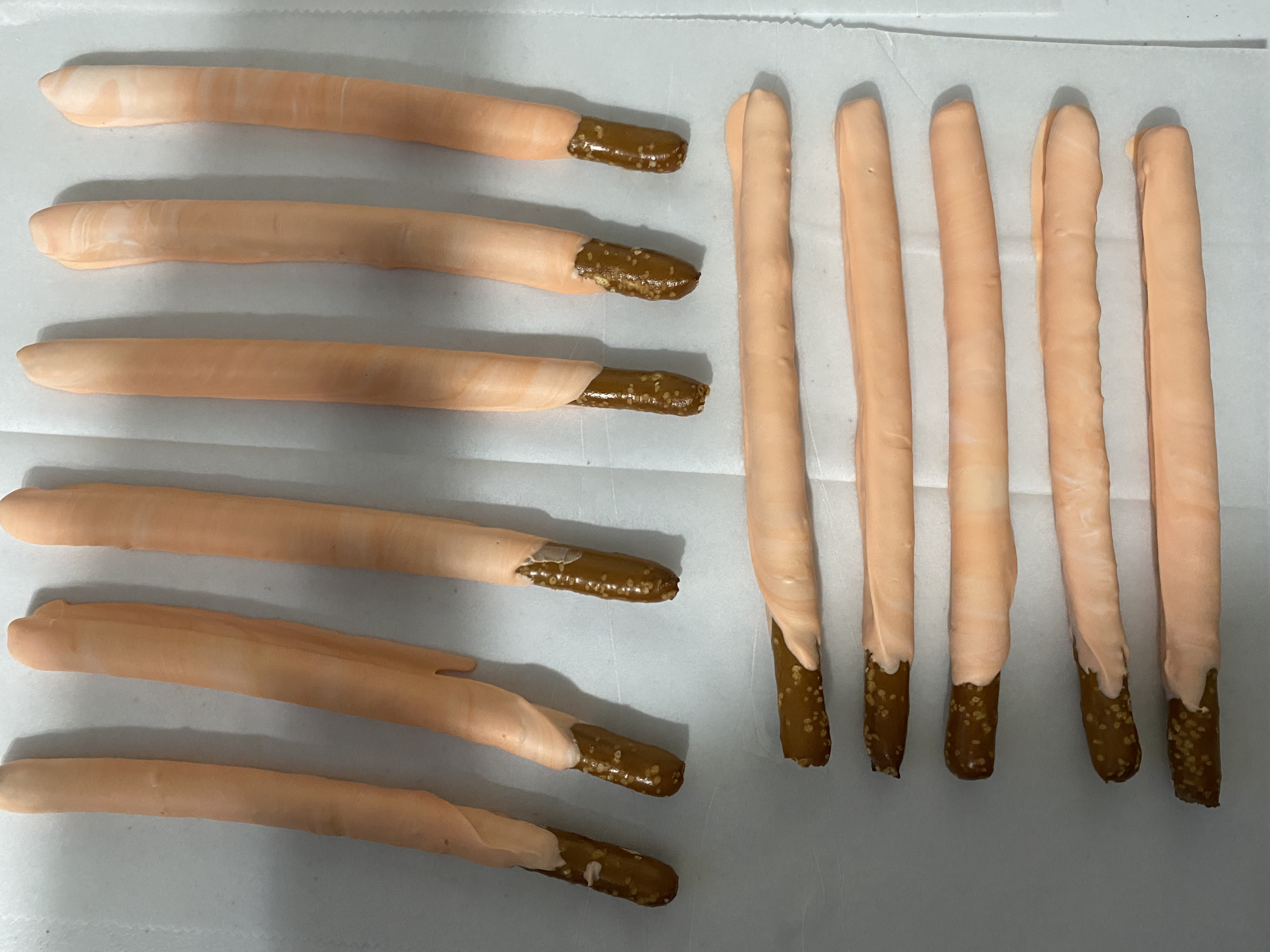 Pretzel rods dipped in peach-colored coating